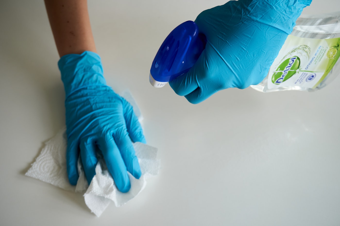 Désinfection des surfaces avec gants et produit virucide